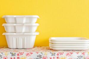 Stacked White Food Containers Against a Yellow Background. A clean and minimalist image of reusable food storage containers. photo