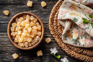 Aromatic Resin Pieces in Wooden Bowl Top View of Natural Amber on Rustic Wooden Background. photo