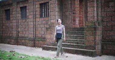 Young woman walking around, admiring the natural scenery and ancient brick structures, Enjoy holiday travel. video