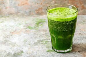 Refreshing Green Smoothie in a Glass on Textured Surface. A close-up image showcasing a vibrant green smoothie, perfect for health and wellness themes. photo