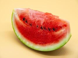A slice of watermelon on a yellow background photo