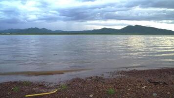 sunset in the evening with a vast reservoir and mountains. video