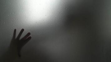 shadow of the right hand and left behind the glass is video