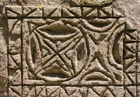 fragment of a pattern carved into stone, textured background photo