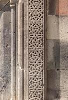 Pattern carved into the stone wall of an ancient temple, Gerhard, Armenia photo