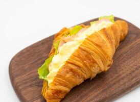 Smoked Ham Egg Salad Croissant on Wooden Board isolated on white background side view of Savory Breakfast photo