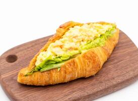 Smoked Salmon Egg Salad Croissant on Wooden Board isolated on white background side view of Savory Breakfast photo
