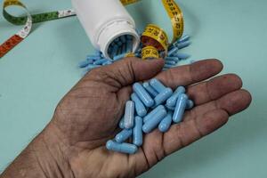 bottle of pills, some of which spilled onto a light blue surface 2 photo
