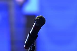 Spherical head of a stage microphone in a blurred environment. Dark lighting and blue background photo