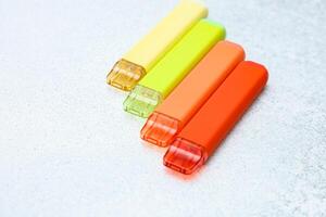 Colorful disposable electronic cigarettes arranged neatly on a light surface photo