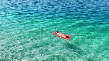 Relaxing on a floating mat in the clear waters of Croatia's stunning coastline during a sunny day video