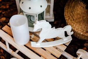 Decorative wooden rocking horse and lantern on rustic table in cozy indoor setting photo