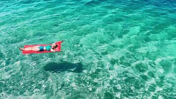 Relaxing in the crystal clear waters of Croatia while floating on a colorful mat under the sun video