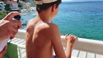Protecting skin from sunburn while enjoying a coastal view with family on a sunny day video
