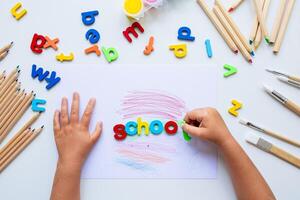 Children hands arranging colorful alphabet letters for learning activity photo