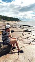 A contemplative young person enjoys their time by the shore on a warm, sunny day video