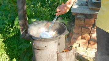 Stirring Hot pilaf in a Traditional Outdoor Pot with a vibrant, artisan approach video