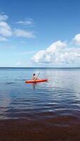 A person is kayaking gracefully on a serene and picturesque lake beneath a sky video