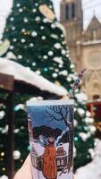 A winter scene with a decorated Christmas tree and a warm beverage video