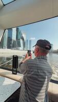A man skillfully capturing a stunning cityscape while enjoying a leisurely boat video