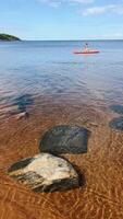 A kayaker enjoys a peaceful moment in serene waters, surrounded by a shoreline video