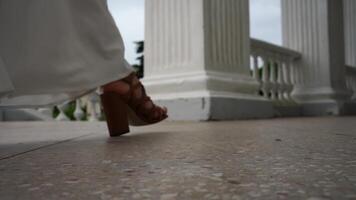 Heels Columns Wedding. Bride walks in sandals by columns on wedding day, expressing love for new beginnings. video
