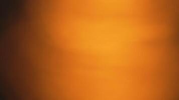 A blurry orange background with a dark brown foreground video