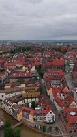 Aerial view of Nuremberg, Bavaria, Germany, showcasing red-roofed historic buildings, churches, with the Pegnitz River flowing through the city under a cloudy sky. June 3, 2024. Nuremberg, Germany video