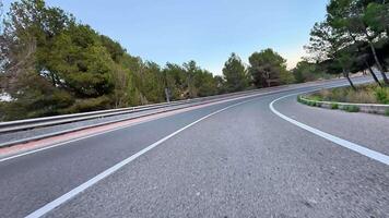 A stunning, beautiful winding road that is embraced by lush greenery and majestic mountains, ideal for scenic drives video