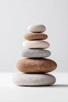 Stack of smooth multicolored zen stones arranged in balance on a light background photo