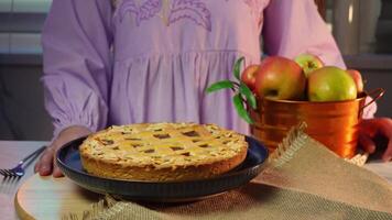 Woman serving homemade apple pie with apples in rustic kitchen setting video