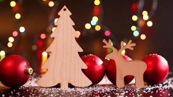 Wooden toy deer and tree on a dark table with white snow video