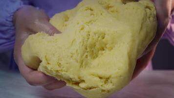 Kneading dough, closeup of hands shaping soft yellow pastry on marble surface video