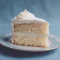 Slice of Layered White Cake with Frosting on Decorative Plate photo