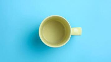 Empty Pastel Yellow Mug on Bright Blue Background photo
