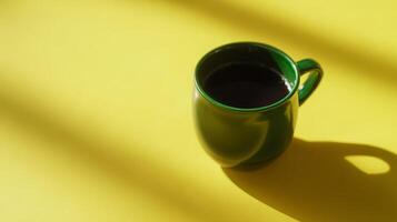 Green Ceramic Coffee Mug on Yellow Background with Sunlight Shadows photo