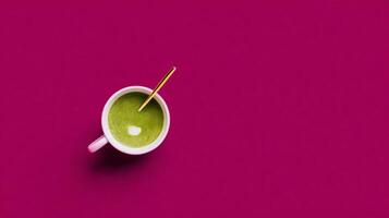 Overhead View of Matcha Latte in White Cup on Magenta Background photo