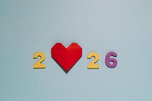 2026 with a vibrant red origami heart on blue. Perfect for themes of love, hope, and the future year. photo