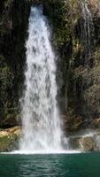 a waterfall is seen in the middle of a green river video