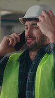Mad Caucasian guy talking mobile phone in construction controller electrician male handyman arguing connection smartphone builder frustrated man shouting foreman quarrel anger problem industrial work video