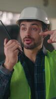 Caucasian builder talk man pointing on walkie talkie in construction electrician contractor male gesturing check radio set sign tech connection guy engineer supervisor communicate building inspection video