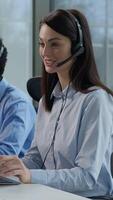 Helpline call service center working multiethnic callcenter workers consulting Indian Caucasian women African man in headset headphones internet trading typing computer desktop customer support office video