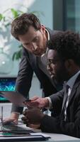 Two people businessmen talking African American employee Caucasian boss leader business working together teamwork discussing project males coworkers looking computer monitor pc online guys in office video