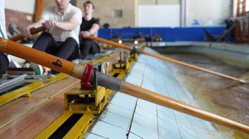 Rowing practice for strength, competition preparation. Group of rowers on sports water simulator. video