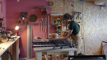 Skilled woodworker beginning project in carpentry workshop, attaching beams with clamps for assembly video