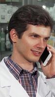 Pharmacist engaged in a phone conversation while examining colorful pill blisters video
