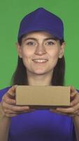 Cheerful delivery woman joyfully presenting a small package to the camera video