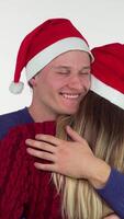 Joyful young couple in festive Christmas hats embracing warmly video