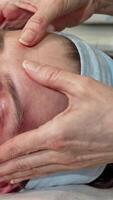 Handsome man indulging in a rejuvenating face massage at a tranquil spa video
