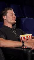 Cheerful young man inviting you to join him for a cozy movie night video